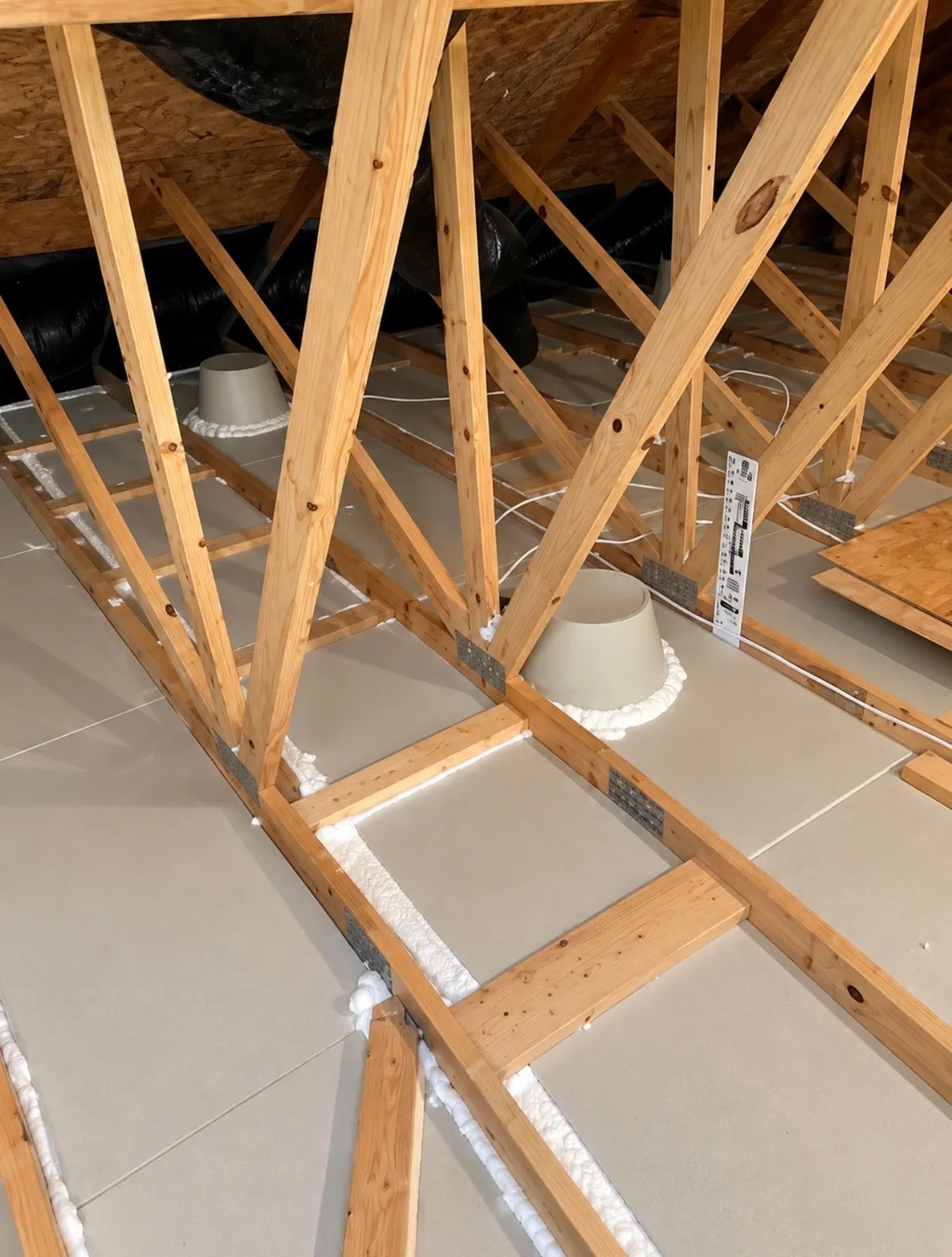Air sealing around attic ceiling penetrations, with spray foam sealing light fixtures and framing at the attic floor